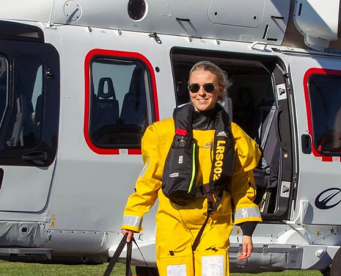 Man en vrouw van bedrijf Biardo Survival Suits stappen uit helicopter in geel pak.