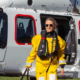 Man en vrouw van bedrijf Biardo Survival Suits stappen uit helicopter in geel pak.